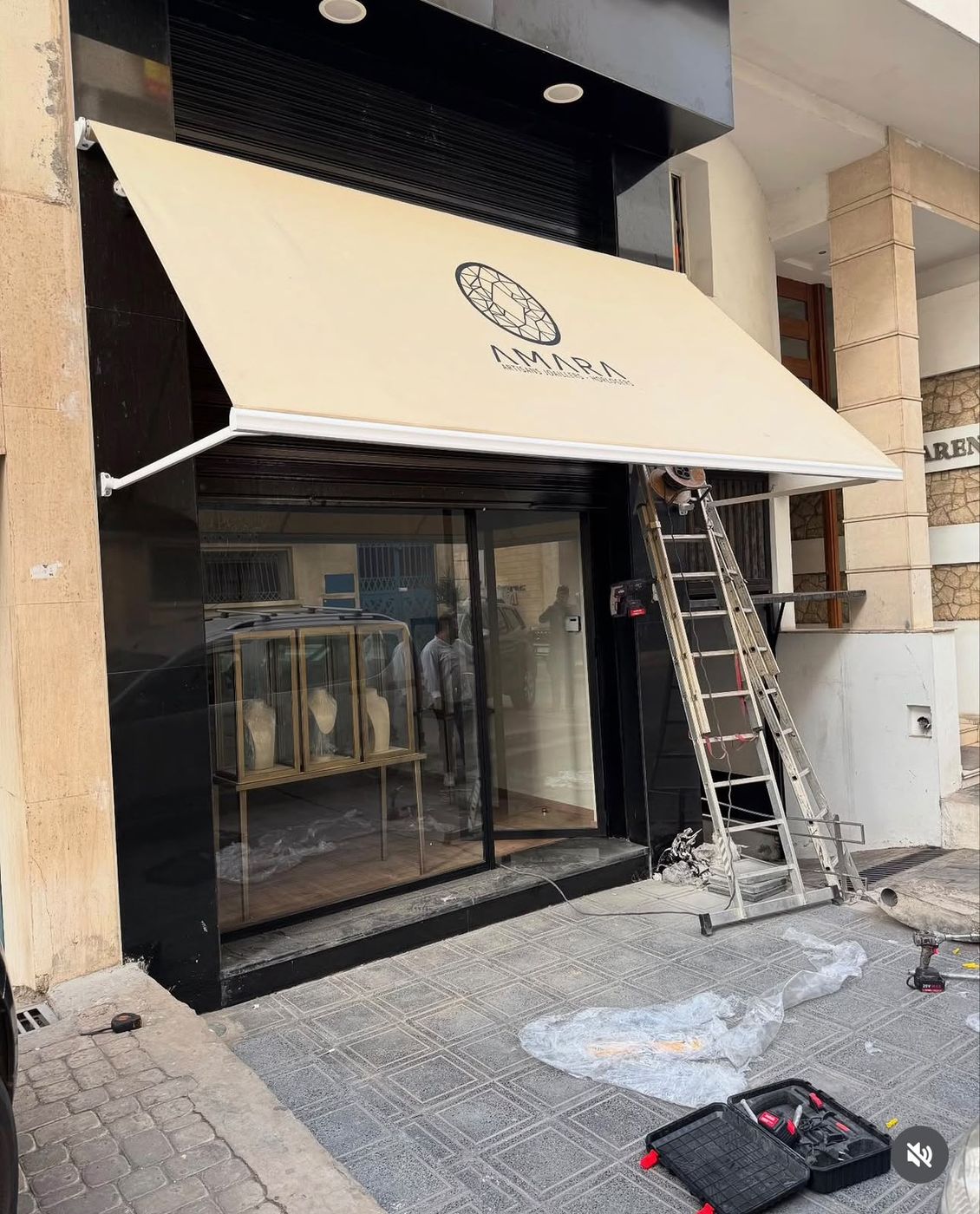 Store bras droit installé sur la vitrine d'une boutique